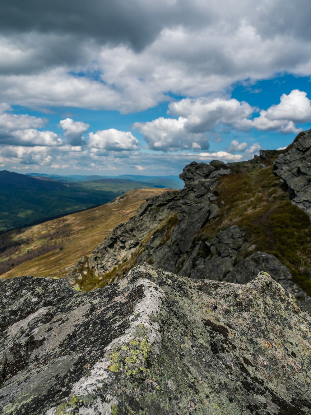 Weiße und graue Wolken schweben über Bergen und Tälern