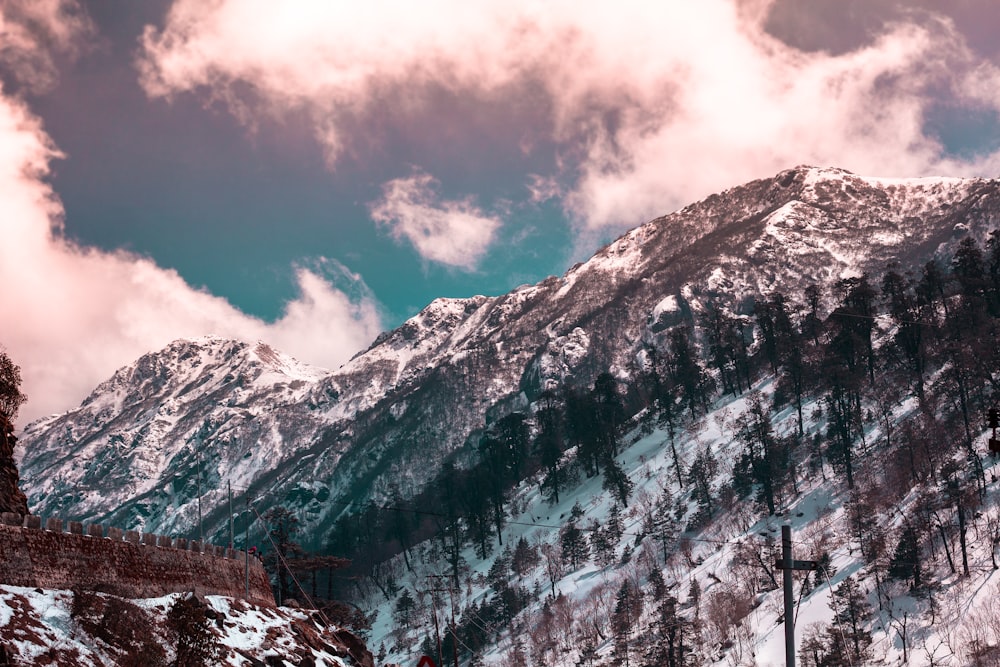 snow covering mountain under white and blue cloudy sky