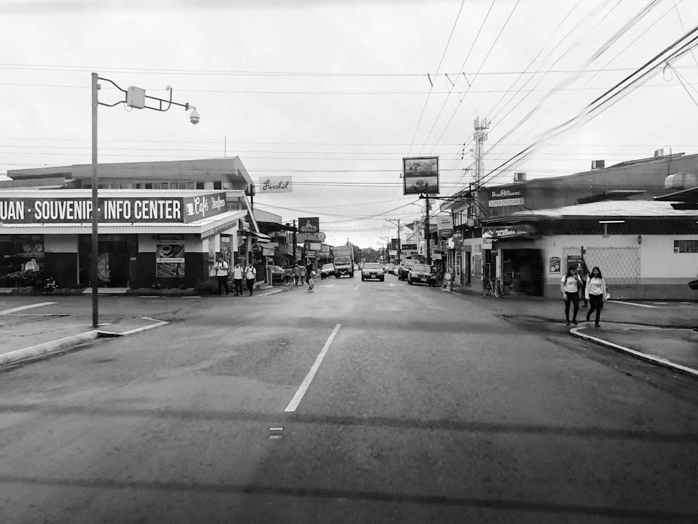 grayscale photo of road between buildings