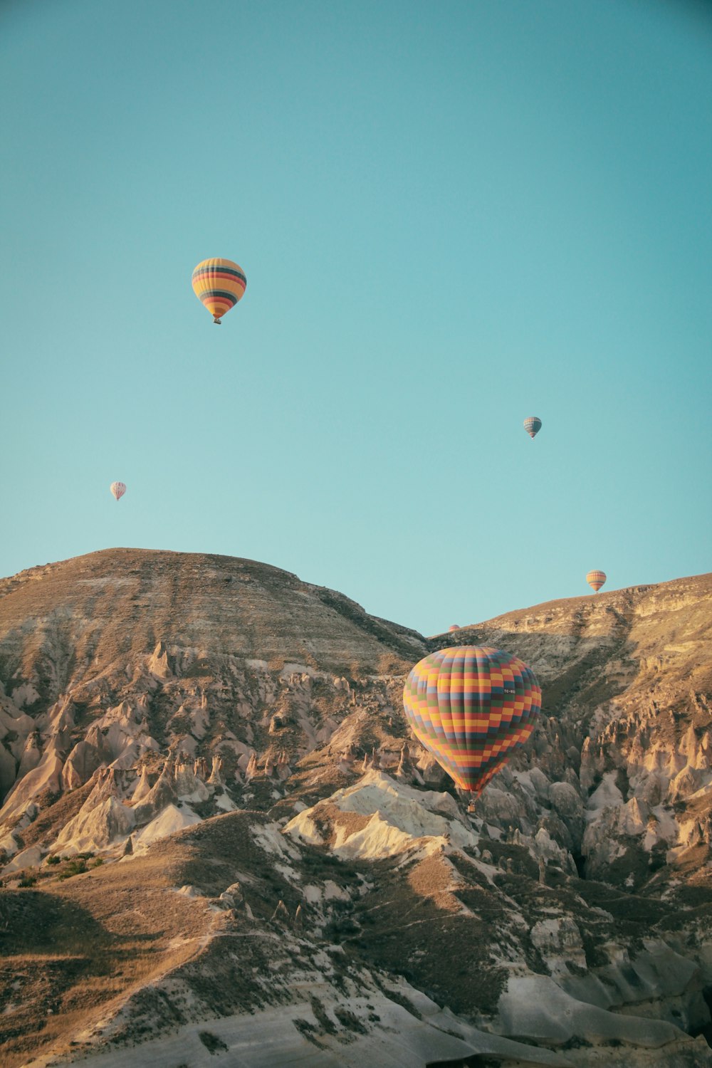 hot air balloons over rocky mountains