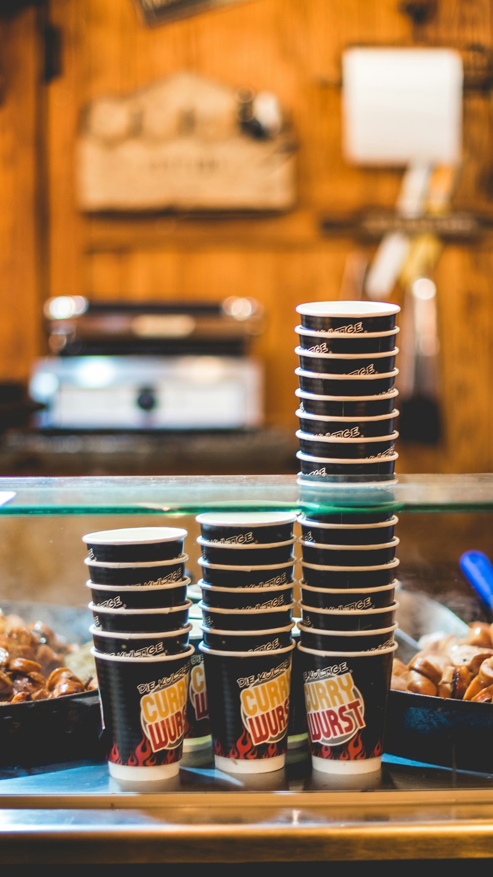 three stacks of Curry Wurst disposable cups on gray surface