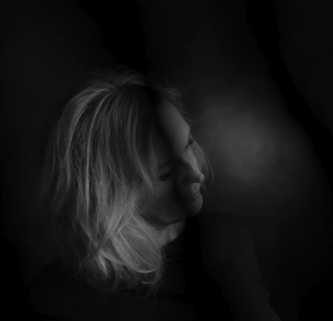 A serene black and white portrait capturing subtle emotions with soft lighting.