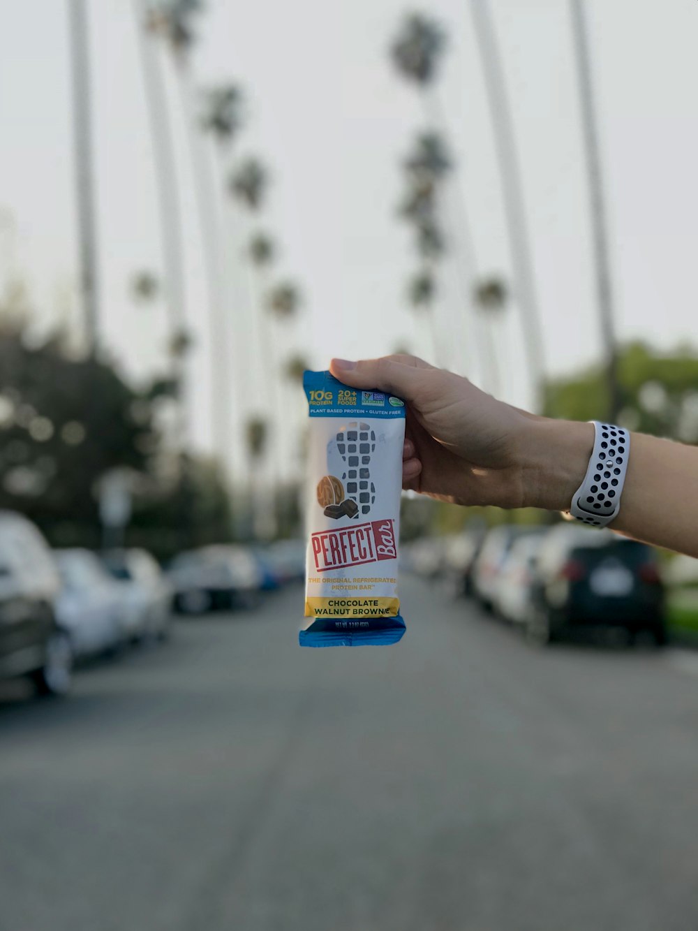 person holding white and blue labeled pack