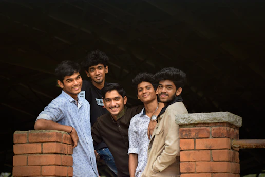 five men standing near bricked post