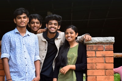 three men and woman standing beside brown post