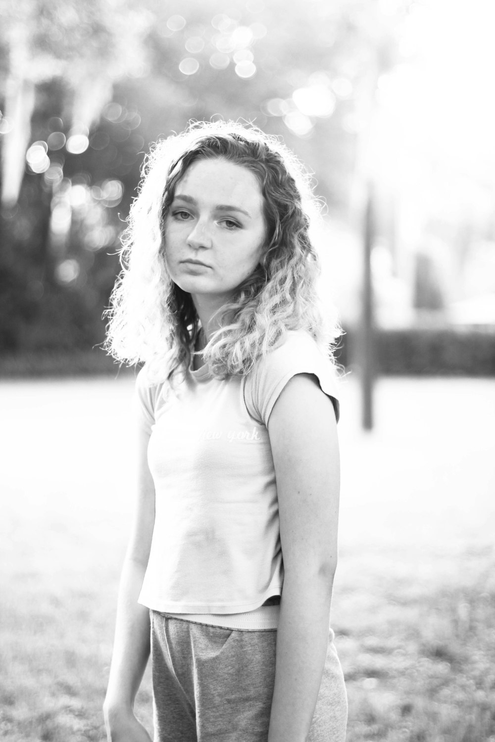 grayscale photo of woman in cap-sleeved shirt