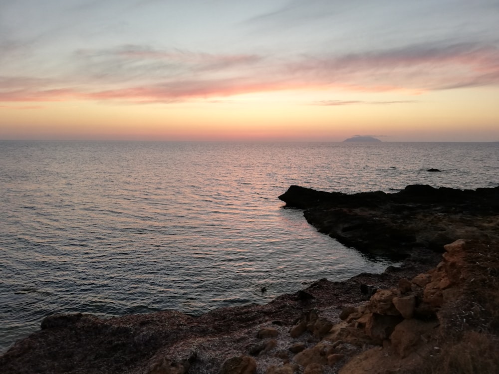 Meeresküste in der Nähe von Felsformationen während der goldenen Stunde