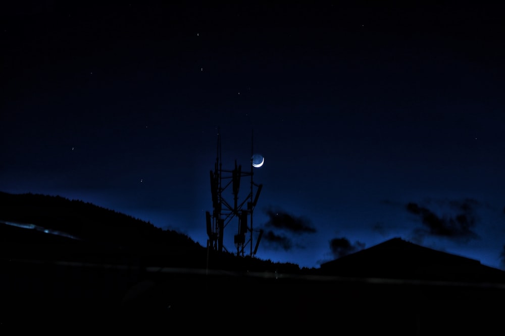 the night sky with the moon and stars in the distance