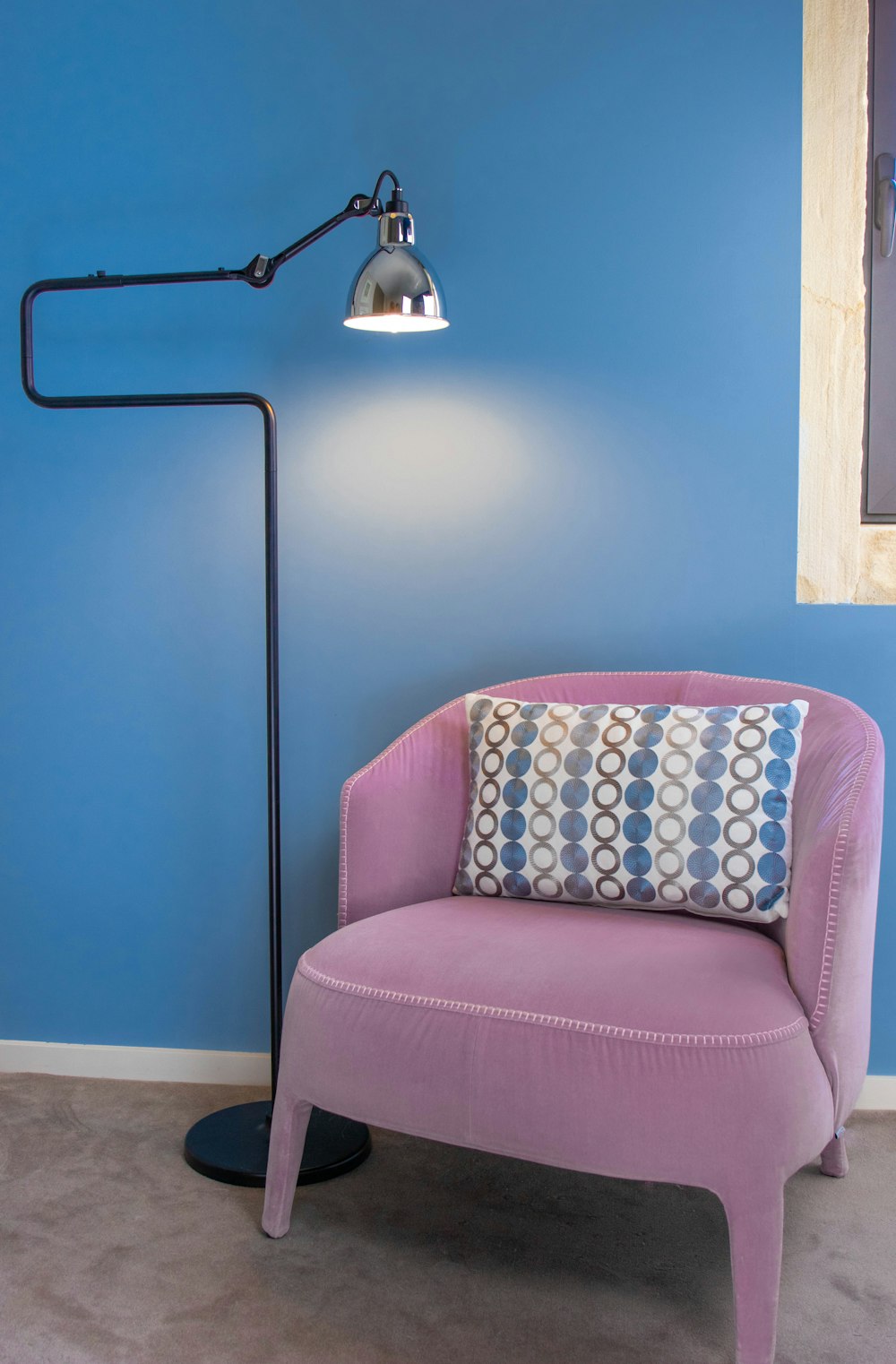 turned-on cantilever lamp beside sofa chair