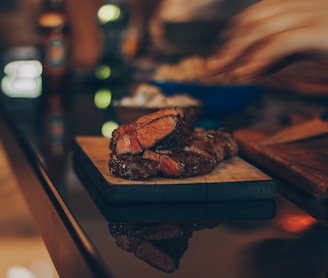 cooked meat on brown wooden chopping board