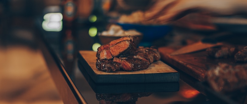 cooked meat on brown wooden chopping board