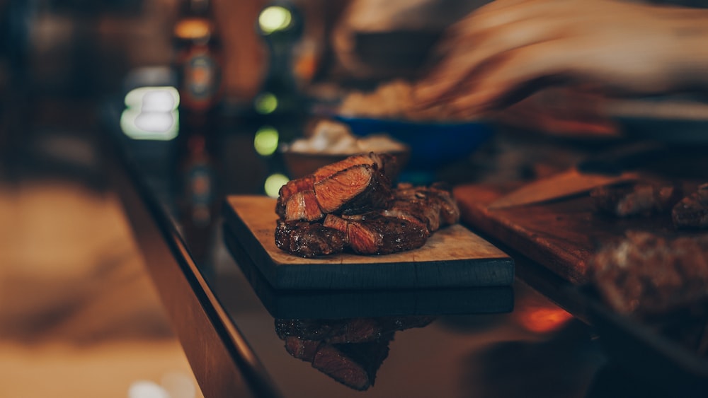 cooked meat on brown wooden chopping board