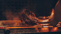 Artistic close-up of high-end picaña sizzling over open flame grill.