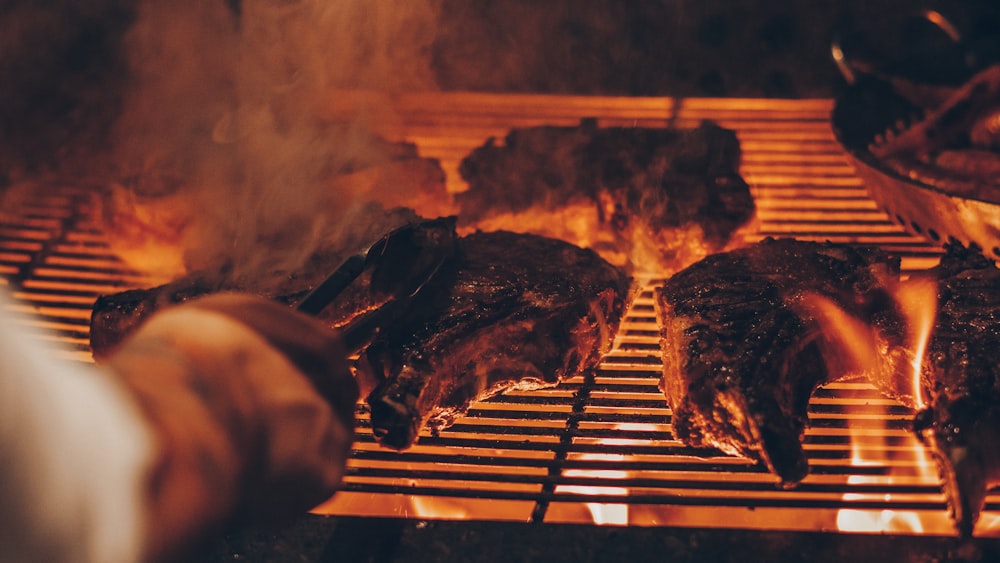 foto em close-up da pessoa grelhando carne