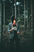 man holding burning paper near trees