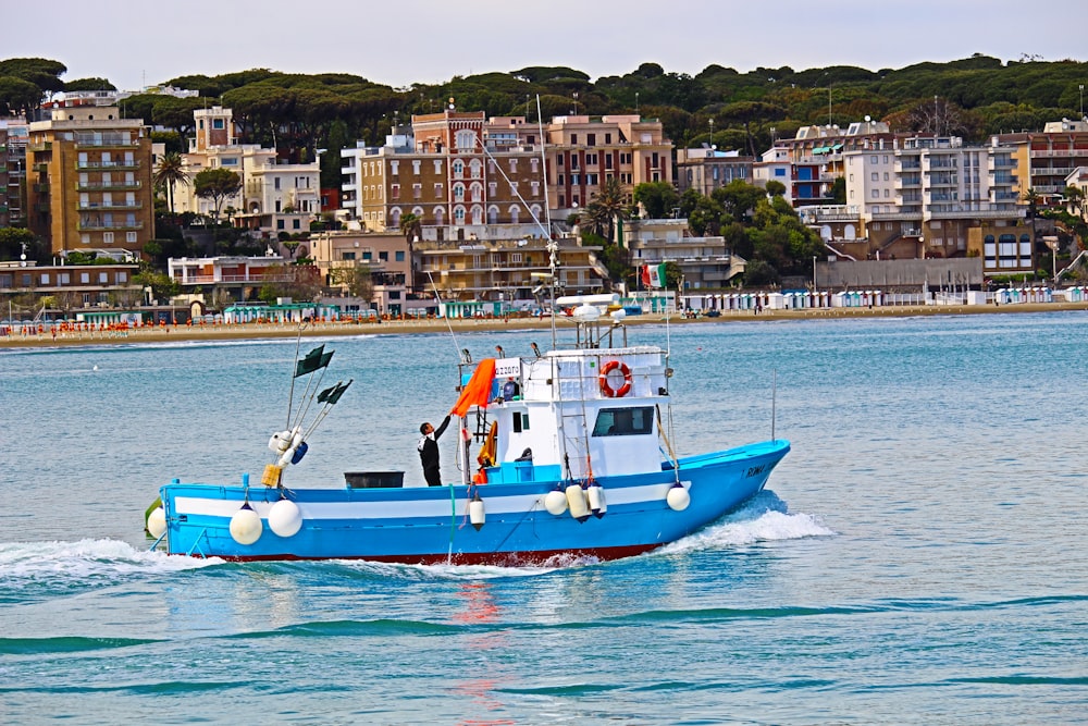 blue and white boat on water at daytime