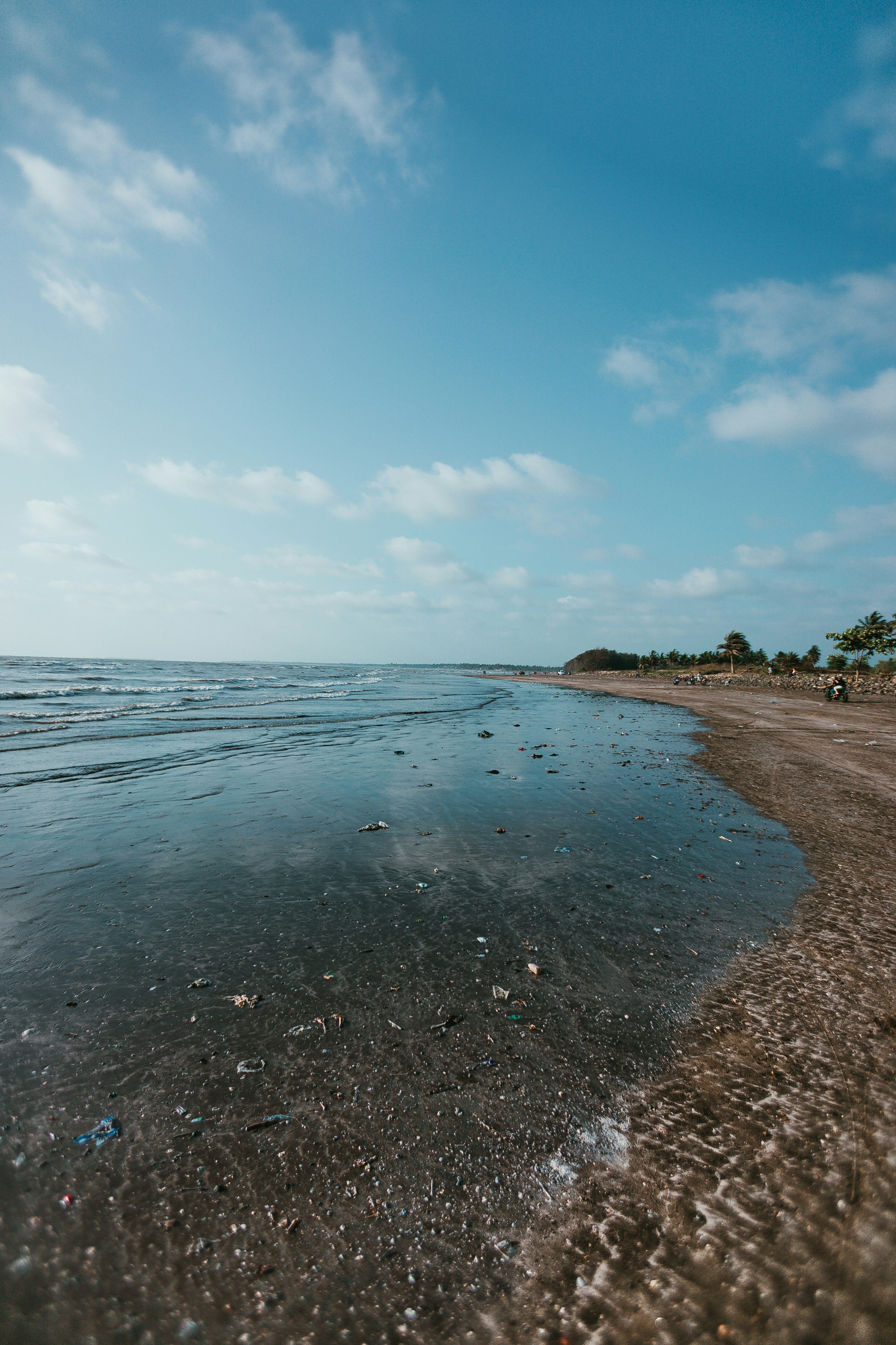 Polluted beach covered in plastic waste and debris, dark stormy sky, toxic environment, dramatic environmental destruction lighting