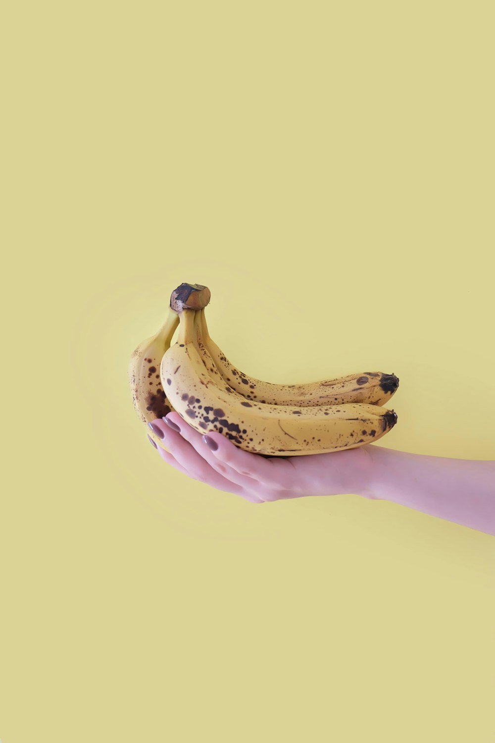 persona che tiene il frutto giallo della banana