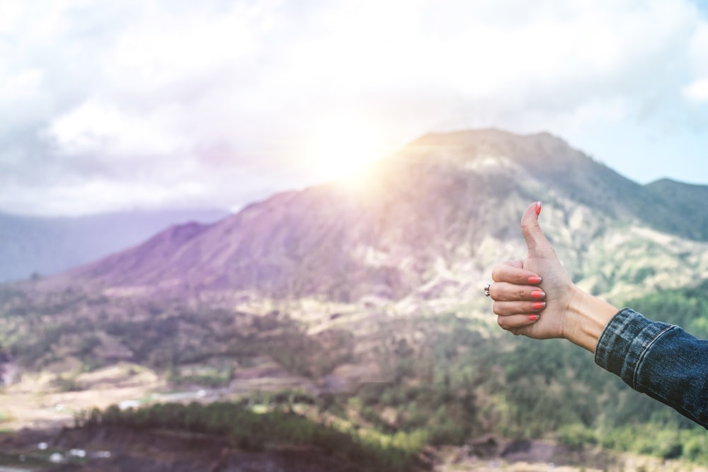 Essere umano che mostra la mano in cima alla montagna