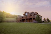 brown wooden house with green grass field