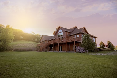 brown wooden house with green grass field