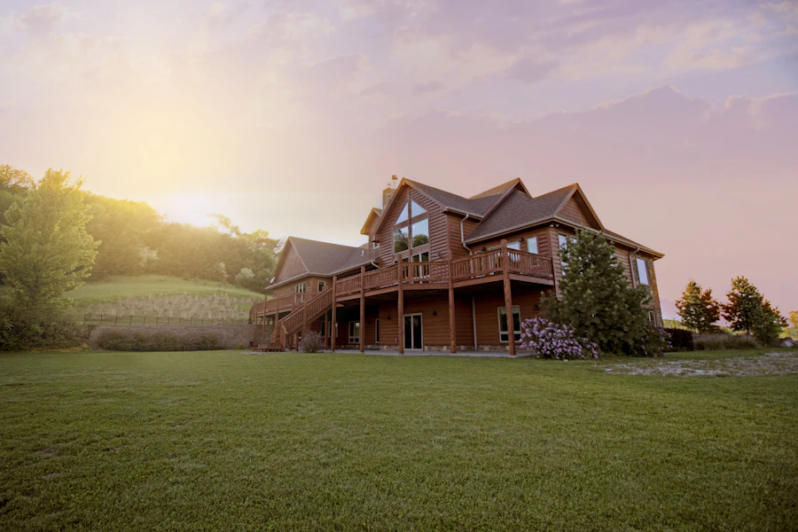 Two-story wood-sided home on a large rural lot at sunset