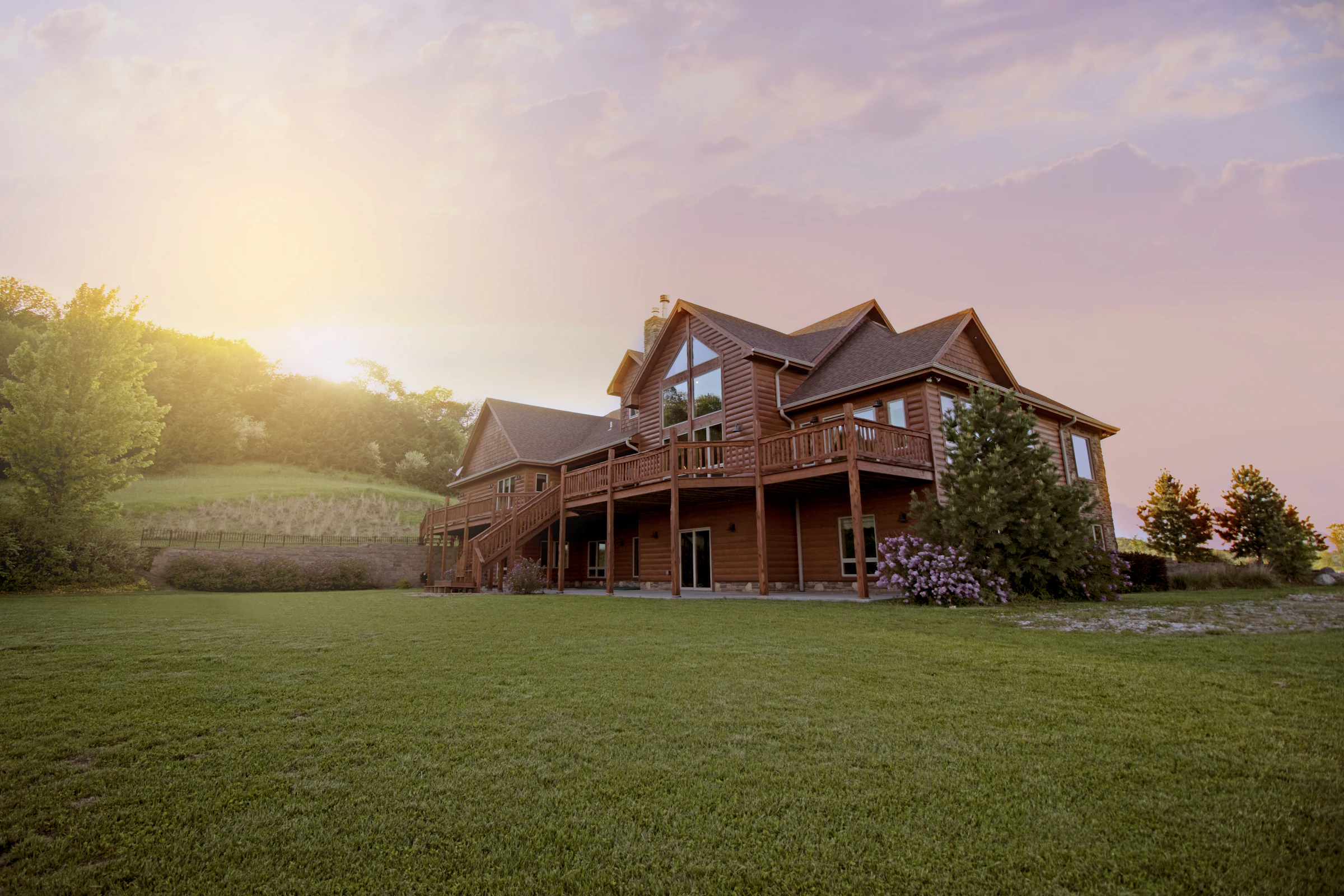 A warm timber-clad modern house set against a green lawn.