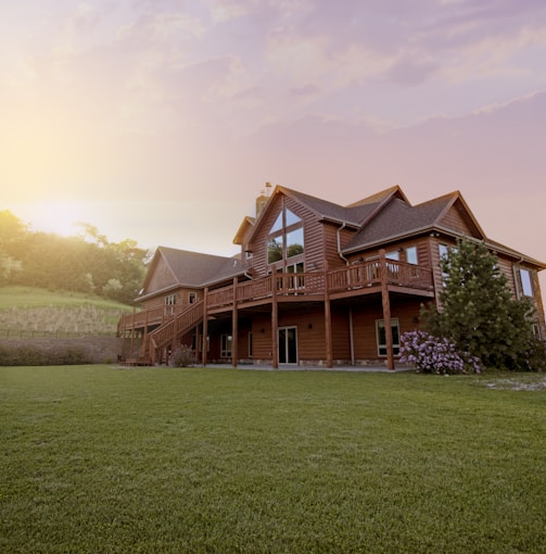 brown wooden house with green grass field