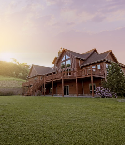 brown wooden house with green grass field