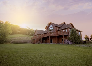 brown wooden house with green grass field