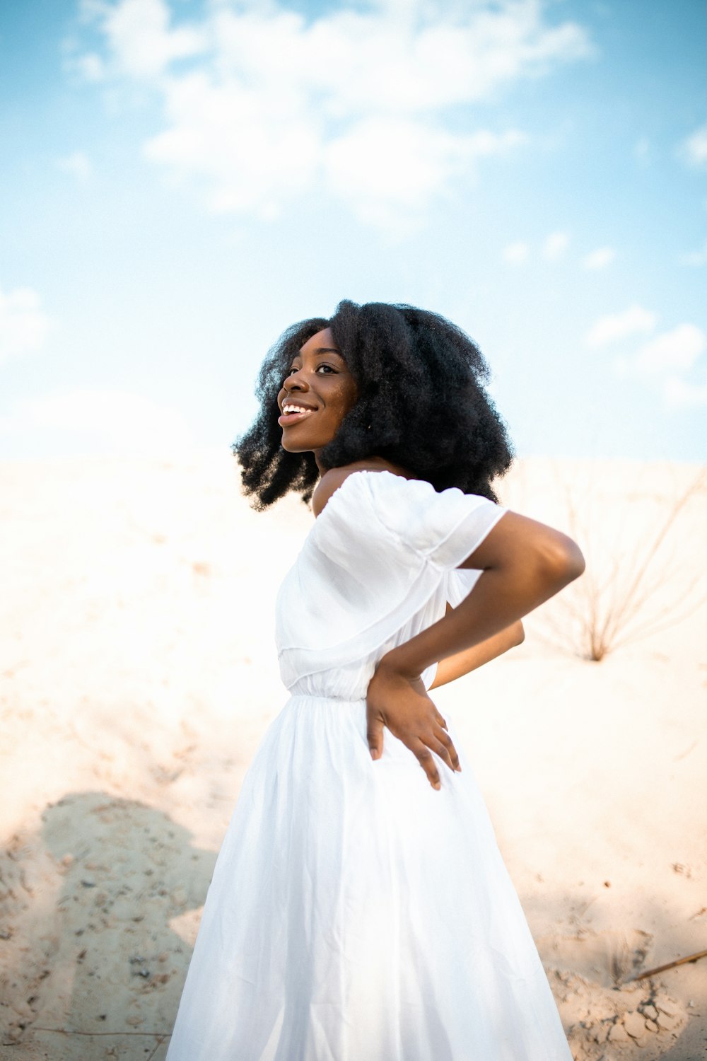 femme portant une robe blanche avec les mains sur la taille