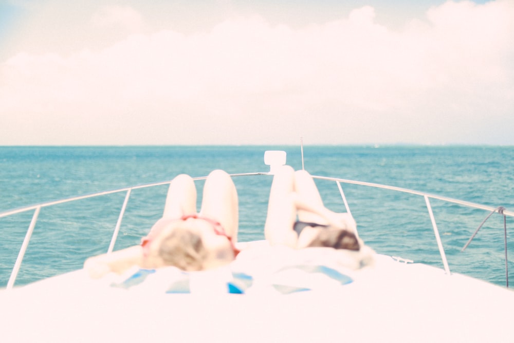 two women lying in front of the yacht under the heat of the sun