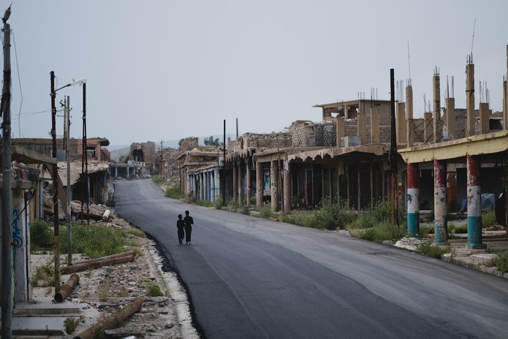 two persons walking on gray raod