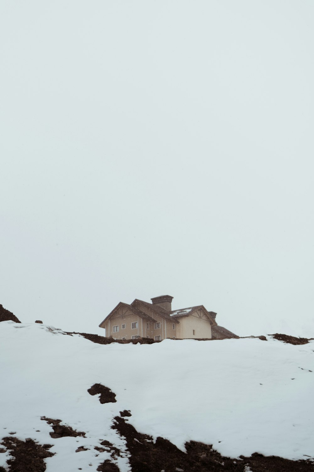 brown concrete building on snow-capped hill