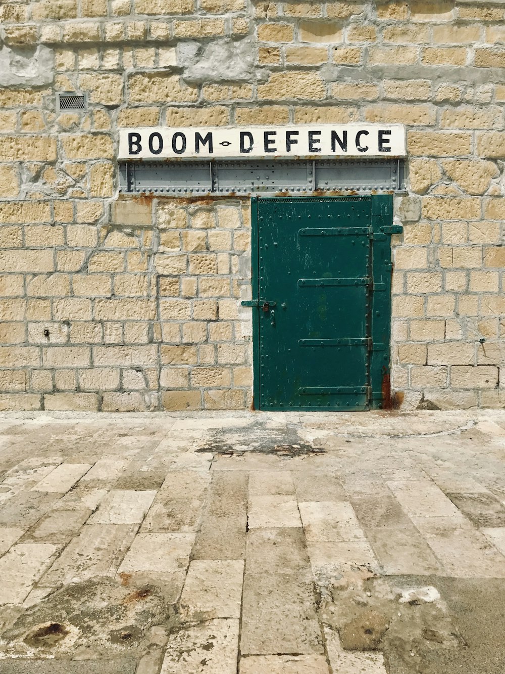 green steel door and Boom Defence signage