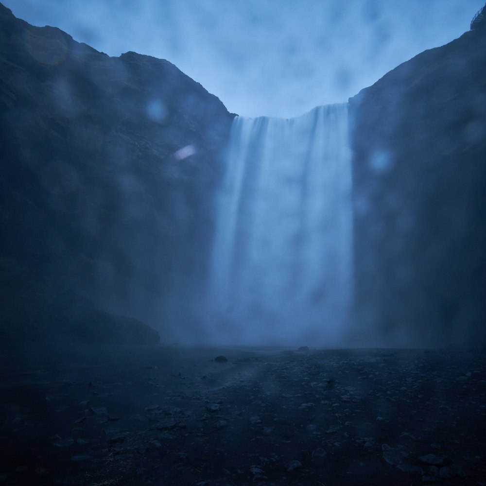 a very tall waterfall in the middle of a mountain