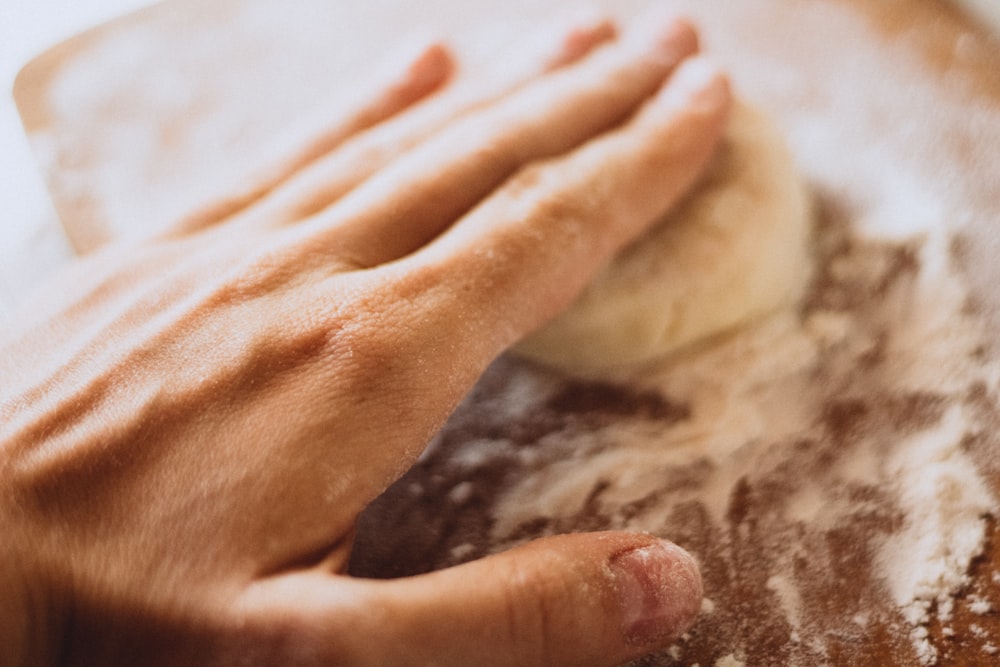 person holding white dough