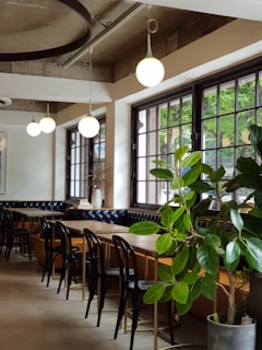 three rectangular brown wooden tables and chairs inside white room