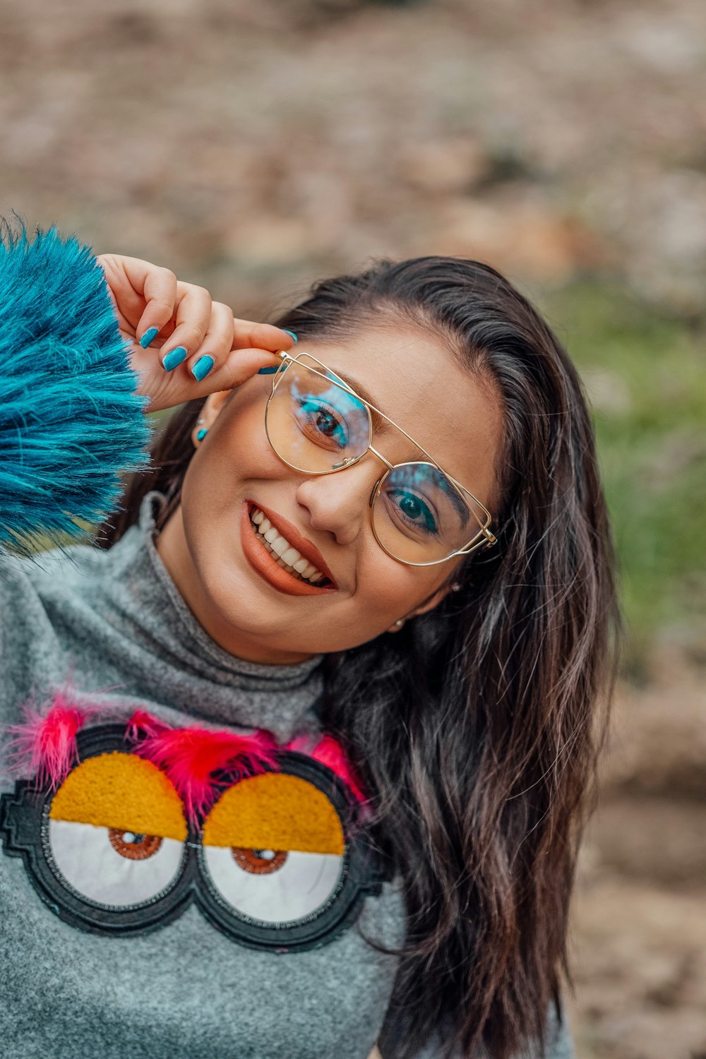 woman smiling wearing eyeglasses while tilting her head to the left