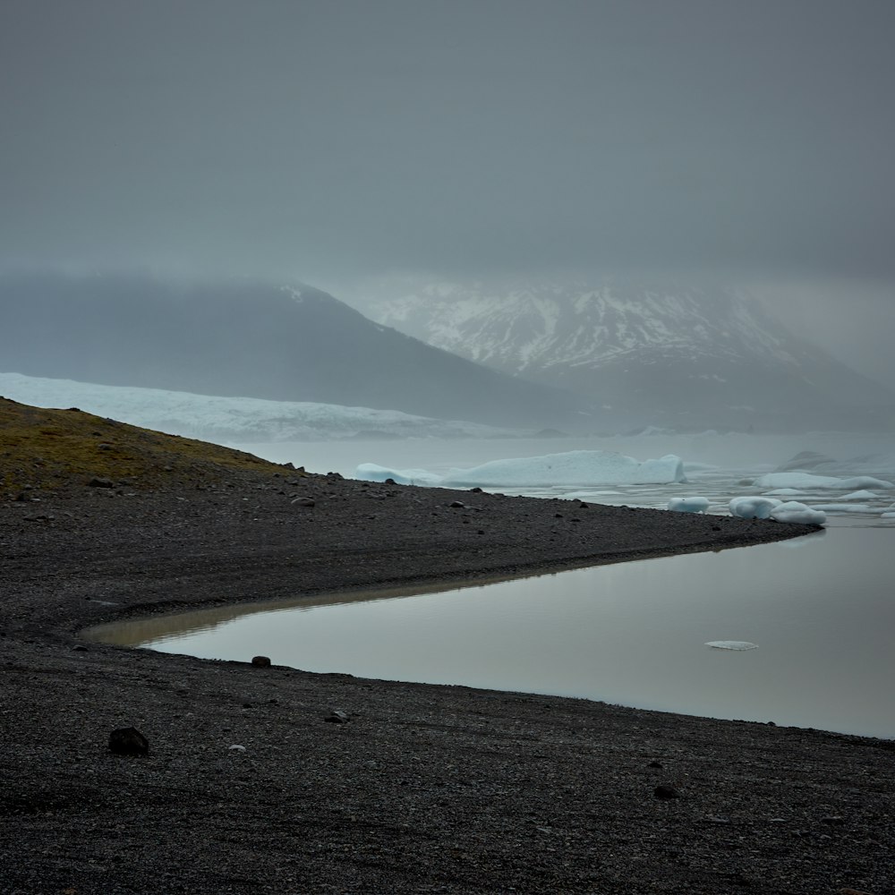 a body of water with a mountain in the background