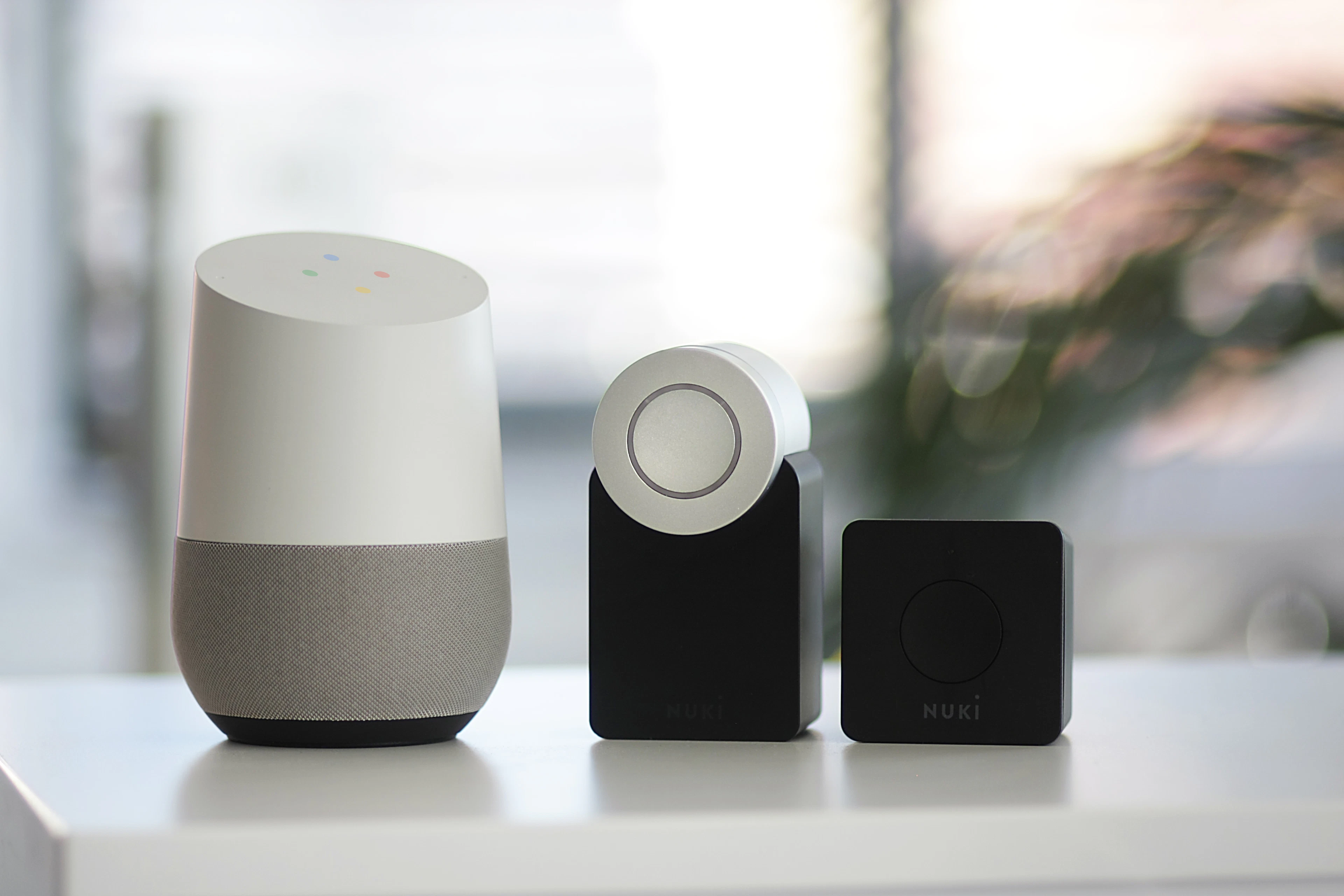 Smart speakers and a smart home hub on a white shelf