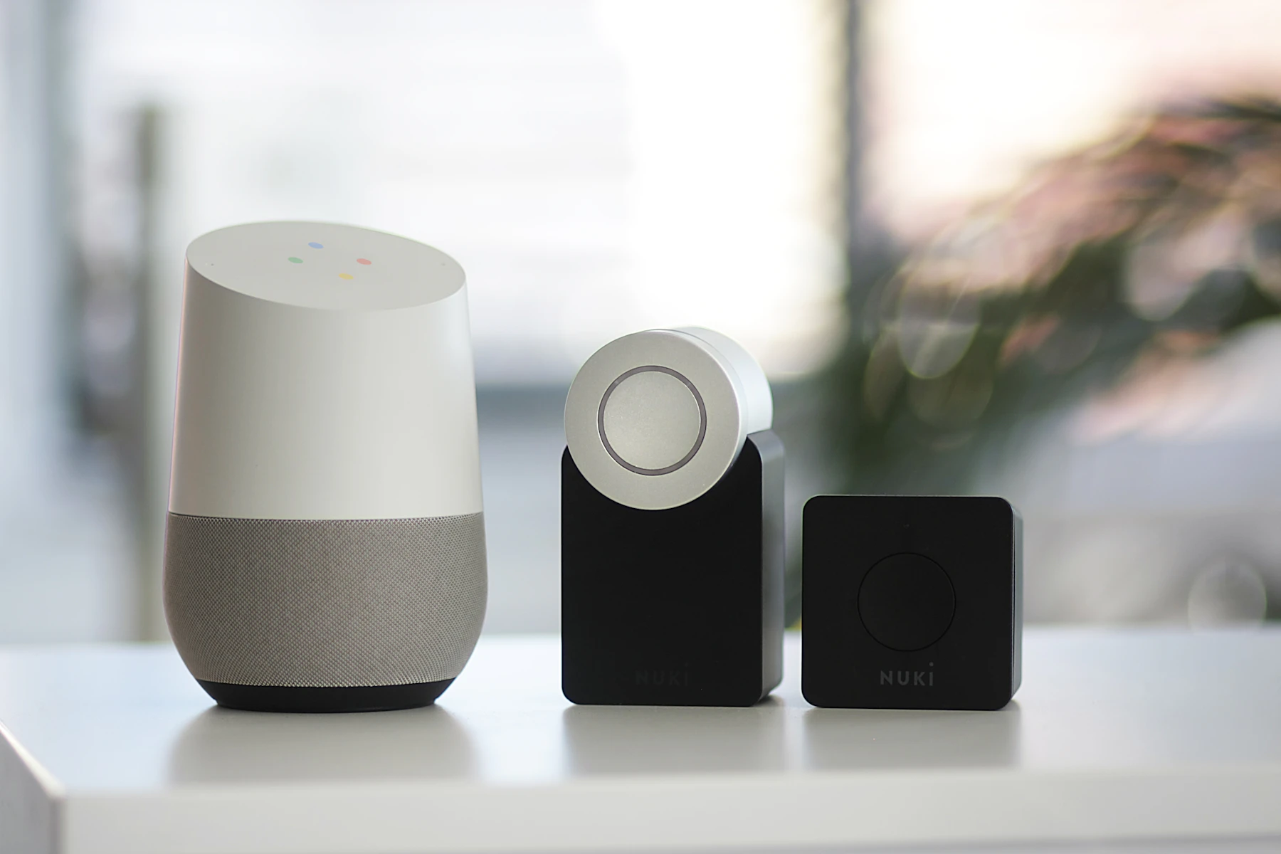 Google smart speaker next to black speakers