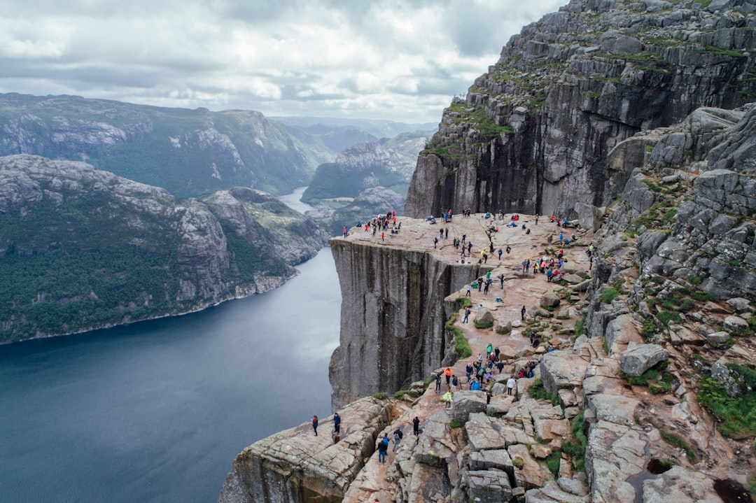 people gathering at the rock plateau overlooking the body of water below