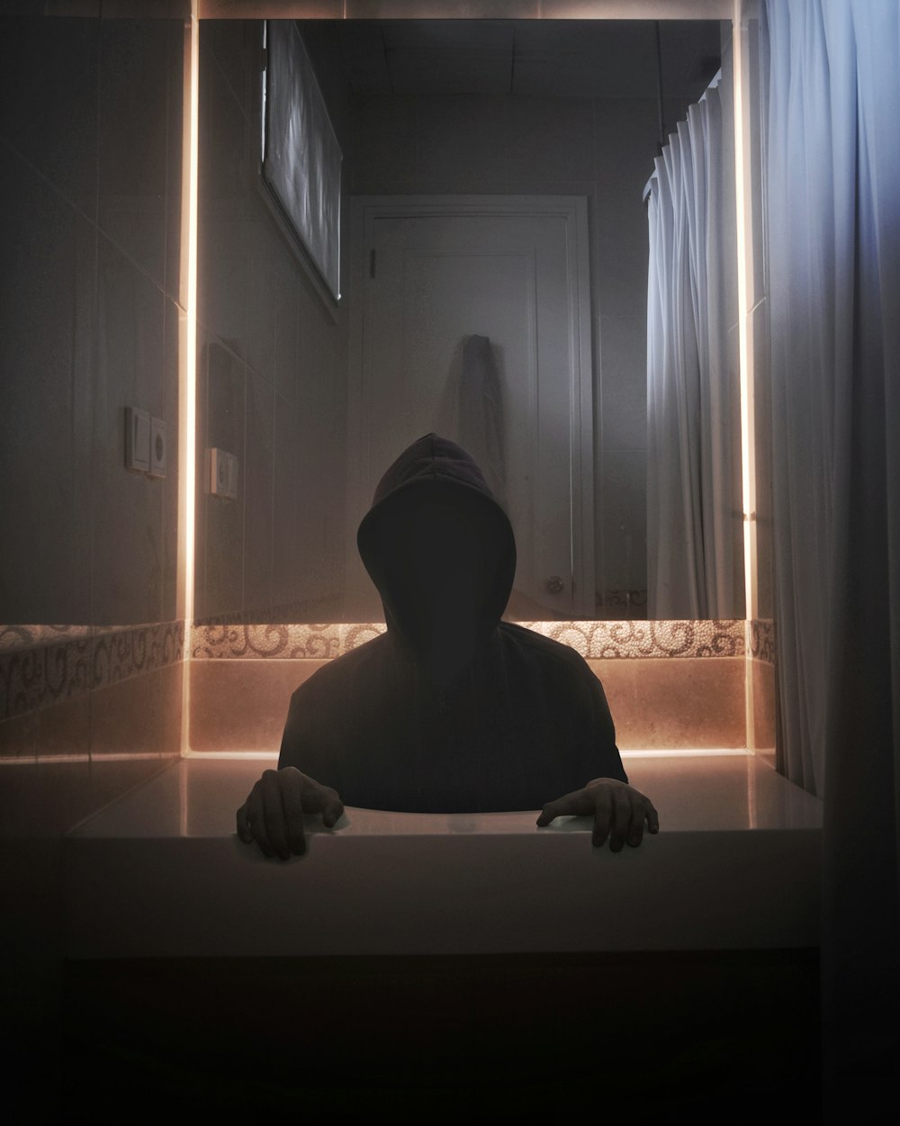 person wearing hoodie inside room