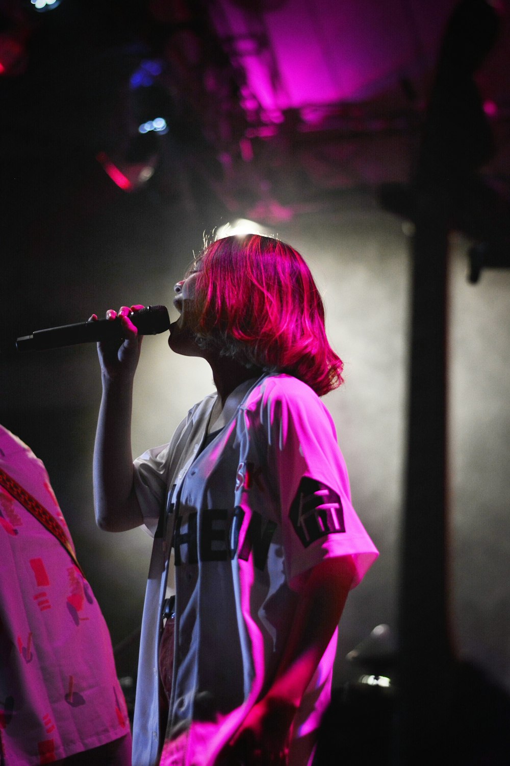 Mujer con camisa blanca cantando en el escenario