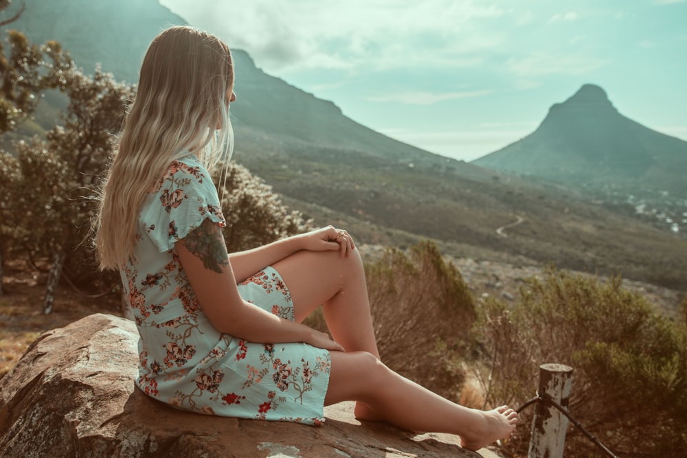 women sitting on a stone in a field during daytime