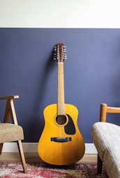 yellow acoustic guitar leaning on wall