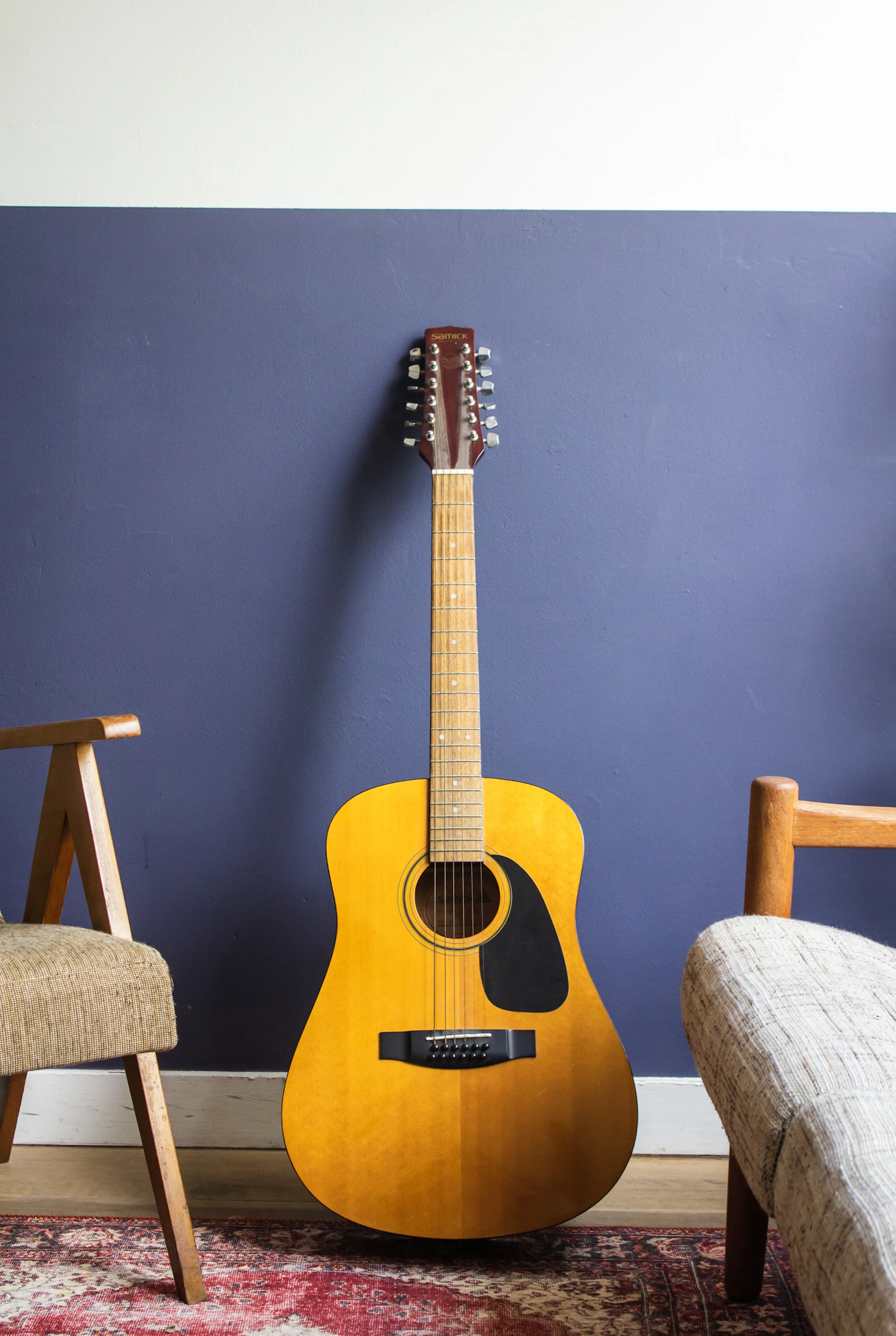 Acoustic guitar resting against a wall