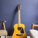 yellow acoustic guitar leaning on wall