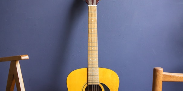 yellow acoustic guitar leaning on wall